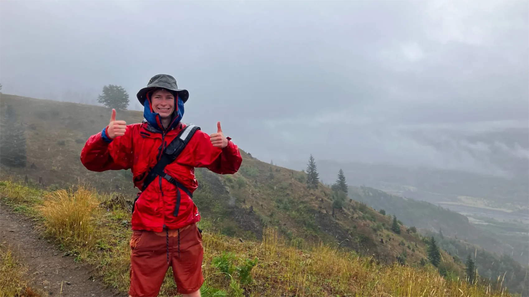 Me driping wet from rain standing infont of a cloudy vista